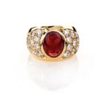 A GARNET AND DIAMOND RING centred with an oval-shaped cabochon almandine garnet weighing