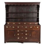AN OAK DRESSER, 18TH CENTURY in two parts, the rectangular outswept cornice above a plain frieze