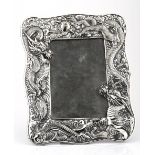 A JAPANESE WHITE METAL PICTURE FRAME applied with relief of two dragons chasing a flaming pearl,
