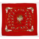 AN HERMES SILK SCARF Traité des Armes by Hugo Grygkar in red. Features images of fencing men.