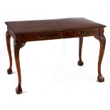 A CHIPPENDALE STYLE MAHOGANY WRITING DESK the rectangular moulded carved top above a pair of