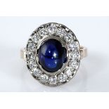 A SAPPHIRE AND DIAMOND RING centred with a cabochon sapphire weighing approximately 4.1cts, within a