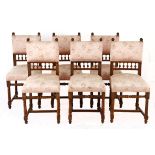 A SET OF SIX EDWARDIAN MAHOGANY SIDE CHAIRS each padded back surmounted by carved finials, the mid-