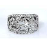 A DIAMOND RING, BROWNS the broad tapered band centred with open scroll work, millegrain-set with