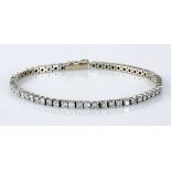 A DIAMOND TENNIS BRACELET claw-set with sixty-one round brilliant-cut diamonds weighing