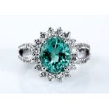 AN EMERALD AND DIAMOND RING centred with a claw-set oval mixed-cut emerald weighing approximately