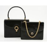 A GUCCI HANDBAG Black leather bag with leather handle and gold clasp. Maroon interior. Made in
