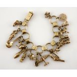 A CHARM BRACELET composed of 18ct gold circular book-link chain suspending seventeen assorted