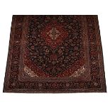 A KESHAN CARPET, PERSIA, MODERN the indigo blue field with a red floral medallion and spandrels