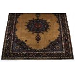 A MESHED CARPET, EAST PERSIA, MODERN the plain camel field with a blue floral star-medallion,