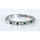 AN EMERALD AND DIAMOND HALF-ETERNITY RING set to the centre with four carré-cut emeralds weighing