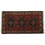 A TURKISH RUG, MODERN The red field with three “Lesghi” medallions depicted in brown and blue within