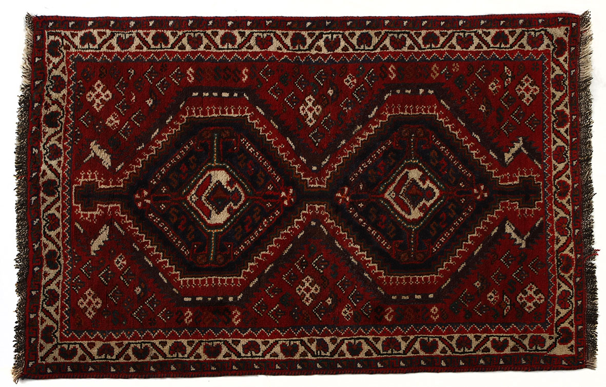 A SHIRAZ RUG, PERSIA, MODERN the red field with two blue diamond medallions within an ivory flower