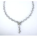 A DIAMOND NECKLACE designed as a series of leaf-shaped links leading into a floral motif,