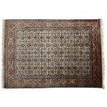 A QUM SILK RUG, PERSIA, MODERN the ivory field with an overall star and vine pattern depicted in