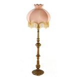A VICTORIAN STYLE GILTWOOD LAMP the bell-shaped fringed shade on a leaf-carved fluted column, on a