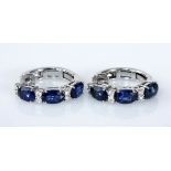 A PAIR OF SAPPHIRE AND DIAMOND EARRINGS each designed as a hinged hoop, claw-set with oval mixed-cut