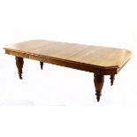 AN OAK EXTENDING DINING TABLE the rectangular moulded top above a plain frieze, canted corners, on