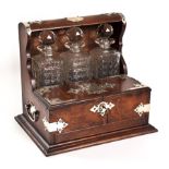 AN OAK AND ELECTROPLATE-MOUNTED TANTALUS, LATE 19TH CENTURY the shaped case enclosing three cut-