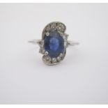 A SAPPHIRE AND DIAMOND RING centred with a claw-set sapphire weighing approximately 1.50cts enclosed