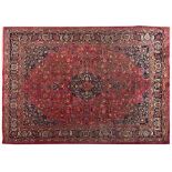 A MESHED CARPET, PERSIA, MODERN the red field with a dark indigo-blue floral medallion and