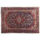 A KESHAN CARPET, PERSIA, MODERN the deep blue field with a red and ivory floral medallion, similar