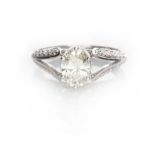 A DIAMOND RING claw set to the centre with an oval-cut diamond weighing 1.04cts, the upswept