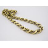 A GOLD NECKLACE designed as a yellow-gold rope-link chain intertwined with a white-gold cable-link