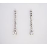 A PAIR OF DIAMOND PENDENT EARRINGS each designed as an articulated line of collet-set brilliant-