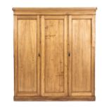 A PINE WARDROBE the outswept pediment above a plain frieze, a pair of panelled doors below enclosing
