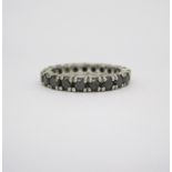 A BLACK DIAMOND ETERNITY RING claw set throughout with circular-cut black diamonds weighing