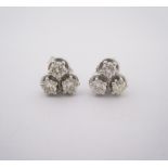 A PAIR OF DIAMOND EAR STUDS each designed as a trio of brilliant-cut diamonds weighing approximately