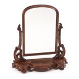 A VICTORIAN FLAME MAHOGANY TOILET MIRROR the arched plate within a conforming frame suspended