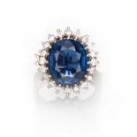 A SAPPHIRE AND DIAMOND RING centred with a claw set oval mixed-cut sapphire weighing approximately