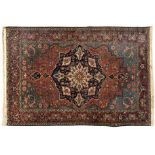 A BAKHTIARI RUG, PERSIA, CIRCA 1950 the madder-red field with a bold indigo-blue floral medallion,