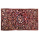 A HAMADAN RUG, PERSIA, MODERN the red field with a blue and red floral medallion, all with