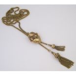 A GOLD LARIAT NECKLACE composed of fancy-link chain terminating in tassels, in sizes, cinched with