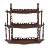 A VICTORIAN ROSEWOOD WALL RACK each shaped shelf surmounted by pierced and carved cresting, joined