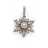 A VICTORIAN DIAMOND PENDANT of open-work design in the form of a snowflake, embellished with old-