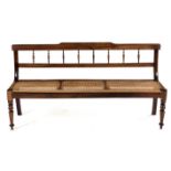 A CAPE REGENCY STINKWOOD RUSBANK the shaped top rail and plain mid-rail joined by turned spindles,