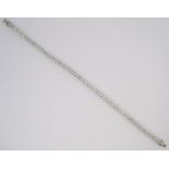 A DIAMOND TENNIS BRACELET designed as a line of claw-set brilliant-cut diamonds weighing