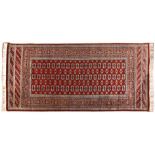 A PAKISTANI RUG, MODERN the red field with three rows of twenty guls and side guls depicted in