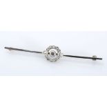 A DIAMOND BROOCH the plain bar centred with a flower motif, centred with a brilliant-cut diamond