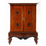 A CONTINENTAL EBONISED AND CHERRYWOOD CUPBOARD, 19TH CENTURY the outswept cornice above a plain