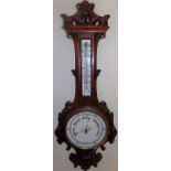 AN OAK ANEROID BAROMETER WITH THERMOMETER, EARLY 20TH CENTURY the carved oak base with floral