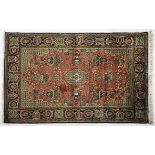 A QUM SILK RUG, PERSIA, MODERN the red field with a small gold floral medallion, similar spandrels