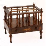 A VICTORIAN WALNUT CANTERBURY the rectangular surround on turned supports surmounted by finials,