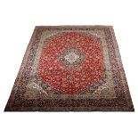 A KASHAN CARPET, PERSIA, MODERN the red field with a floral blue and ivory medallion, similar