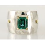 AN EMERALD RING, ORPHEO the broad band with cut-out detail, tube-set with an emerald-cut emerald