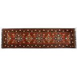 AN AFGHAN RUNNER, MODERN the brown field with five floral medallion depicted in black, ivory, gold